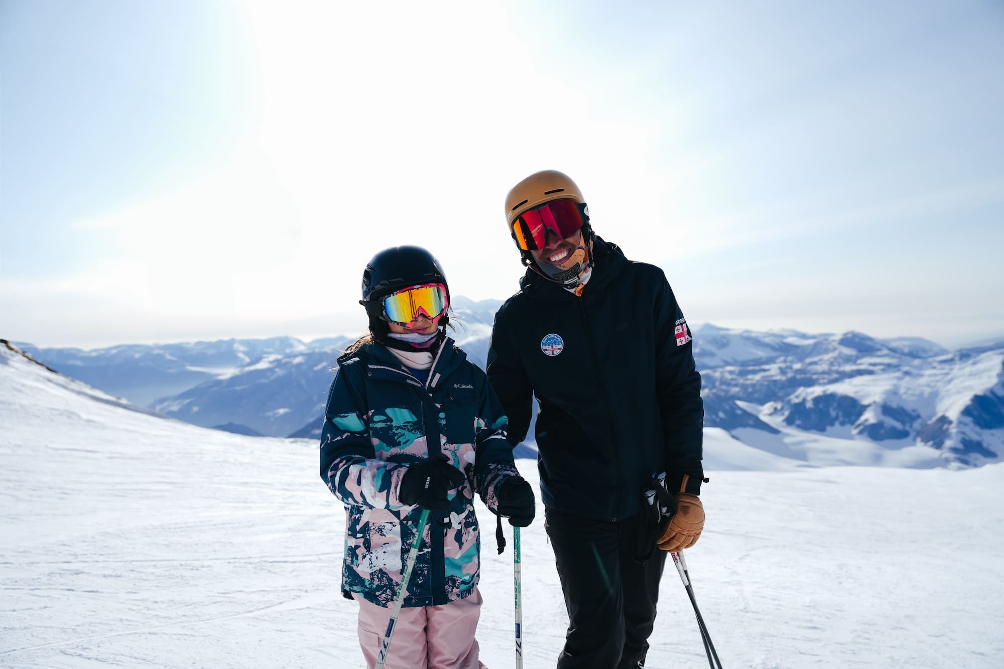Ski instructor of Ski Gudauri School posing on the ski slope with his student.