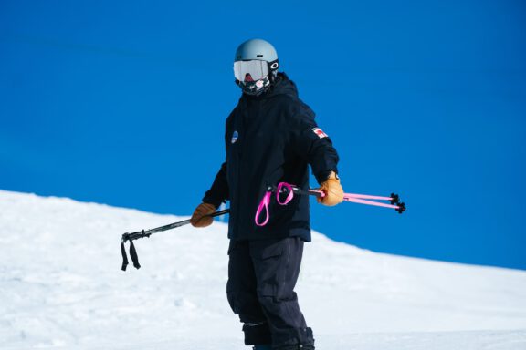 Ski instructor holding the sticks on the slopes.
